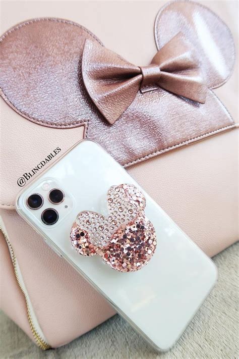 An Iphone Case With A Minnie Mouse Head On It And A Pink Purse Next To It