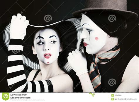 Portrait Of Two Flirting Mimes On A Black Background Stock Photo