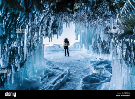 Travelling In Winter A Man Standing On Frozen Lake Baikal With Ice