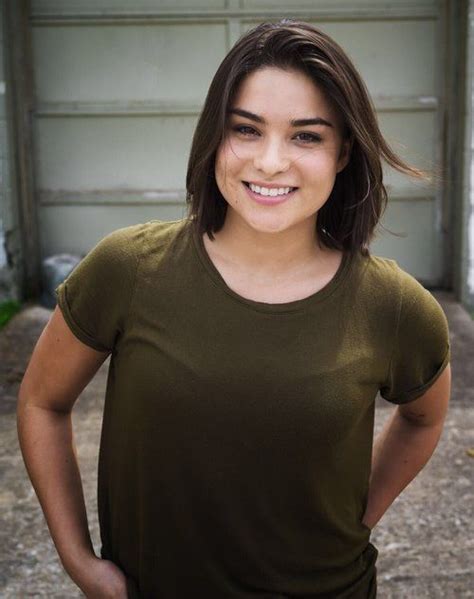 a woman standing in front of a garage door with her hands on her hips and smiling at the camera