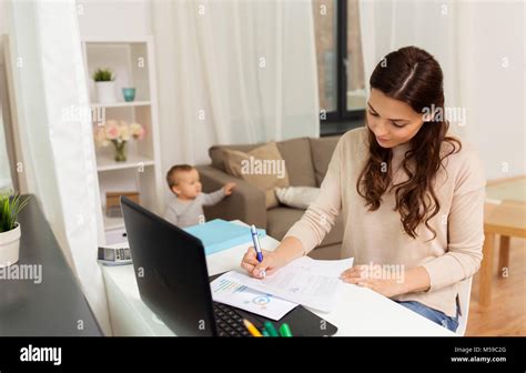 Happy Mother With Baby And Papers Working At Home Stock Photo Alamy