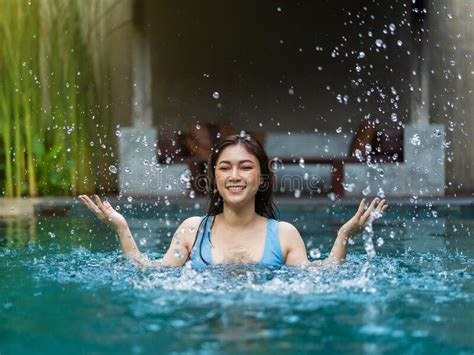 Cheerful Woman Playing Water Splashing In The Swimming Pool Stock Image