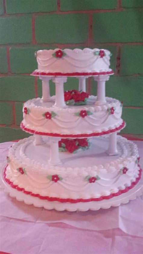 three tiered wedding cake sitting on top of a table