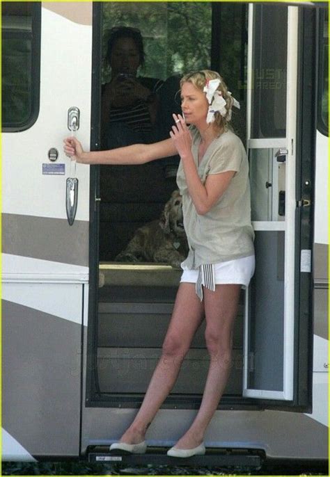 A Woman In White Shorts Standing At The Door Of A Bus With Her Hand Out
