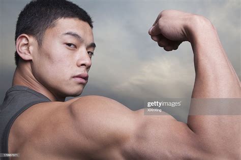 Young Man Showing Off His Bicep Muscles High Res Stock Photo Getty Images