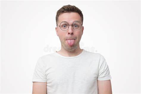 Handsome Young Man In Glasses Shows Tongue Having Funny Mood Stock