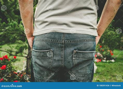 Closeup Shot Of A Male Backside Standing In The Garden Stock Photo