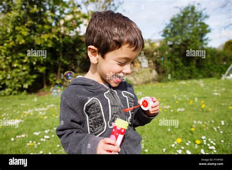 Portrait Of Boy Blowing Bubbles In Garden Stock Photo Alamy