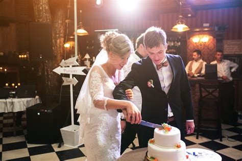 Free Photo Newlywed Couple Cutting Wedding Cake