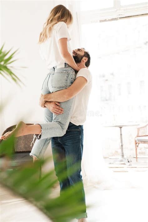 Beautiful Happy Young Couple In Love Embracing At Home Stock Photo