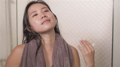 Young Happy And Beautiful Asian Korean Woman Applying Moisturizer
