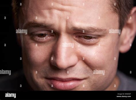 Close Up Portrait Of Crying Young White Man Looking Down Stock Photo