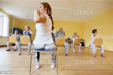 Teacher And Active Senior Women Yoga Class On Chairs Stock Photo