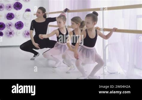 Concentrated Girls Are Learning Basic Ballet Positions In Dancing