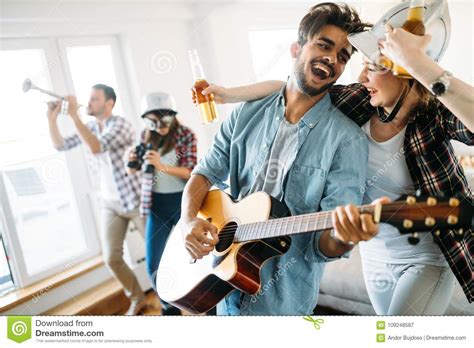 Cheerful Friends Having Party Together And Playing Instruments Stock