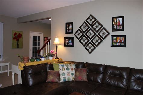 A Living Room With Brown Leather Couches And Pictures On The Wall Above