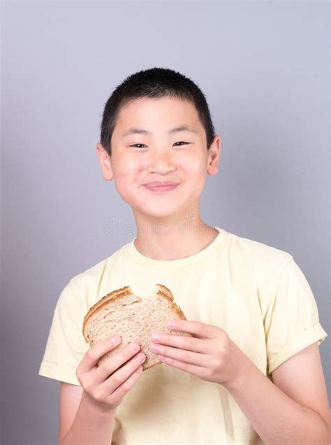 Muchacho Adolescente Asiático Que Come Un Emparedado Imagen de archivo Imagen de coma