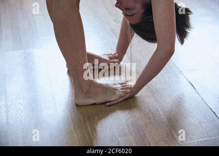 Woman Doing Standing Forward Bend Uttanasana In Group Workout Stock