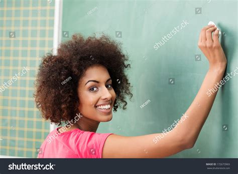 Pretty African American Woman Teacher In Class Writing On The