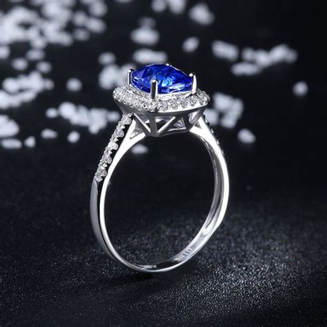 This ring features a stunning 2ct oval cut natural white sapphire. 2 Carat Classic oval cut Sapphire and Diamond Halo Engagement Ring in White Gold - JeenJewels