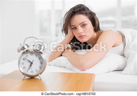 Beautiful Woman In Bed With Alarm Clock On Bedside Table Portrait Of A