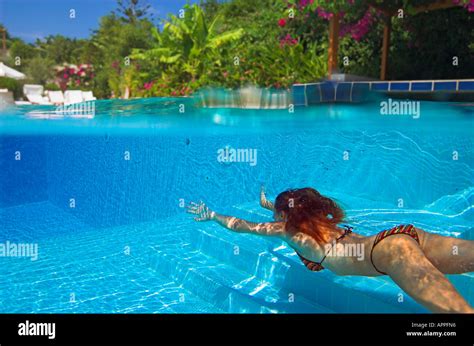 Woman In Bikini Diving Underwater In Swimming Pool Hotel Above Water