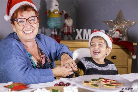 Grandmother And Grandson Having Fun Decorating Cookies On Christmas