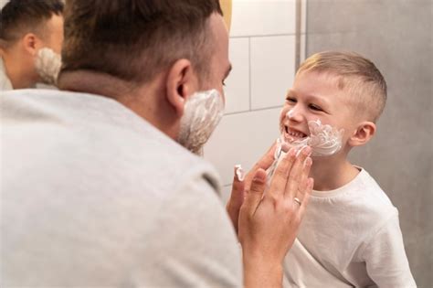 Papá Enseñando A Su Hijo A Afeitarse Foto Gratis