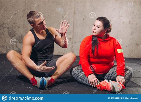 Young Active Pleasant Personal Trainer Talking With His Client Stock