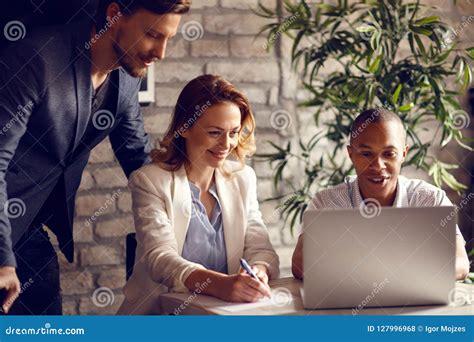 Employees With African Male Supervisor Working In Office Stock Photo