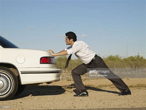 Hispanic Businessman Pushing Back Of Car High Res Stock Photo Getty