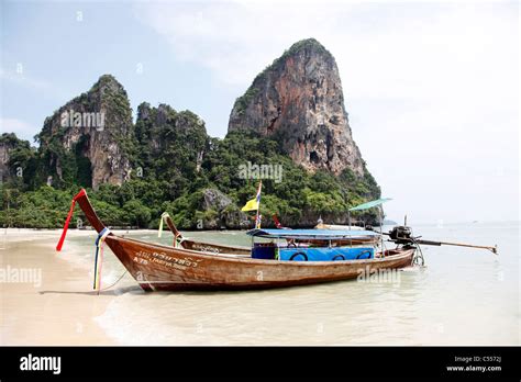 Beach Scene Showing A Traditional Long Tail Thai Boat On The Sandy