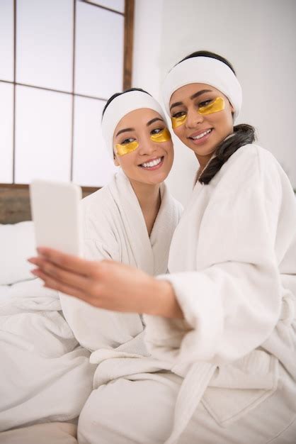 Nuestra belleza pareja de lesbianas positiva tomando fotos mientras está en el salón de spa