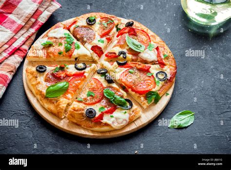 Italian Pizza With Tomatoes Salami Black Olives And Mozzarella Cheese
