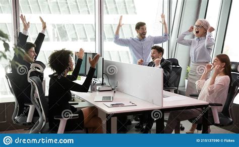 Excited Diverse Employees Celebrate Shared Work Success Stock Photo
