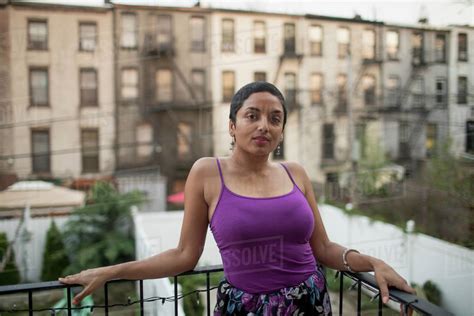 Young Woman Leaning On A Balcony Railing Stock Photo Dissolve