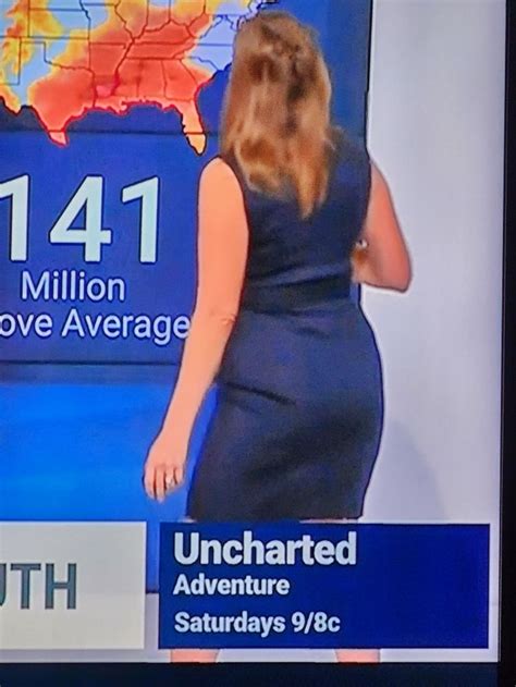 A Woman In A Blue Dress Is On The News With Her Hands Behind Her Back