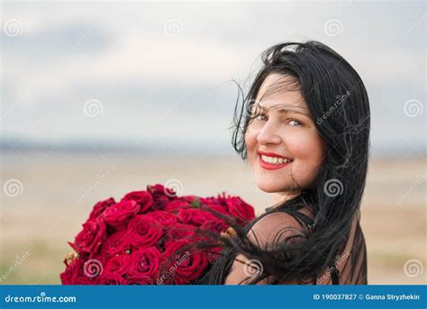 Retrato De Una Chica Tierna De Pelo Largo Negro Con Un Gran Ramo De