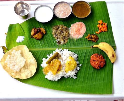 A Banana Leaf With Different Types Of Food On It Including Rice And Sauces