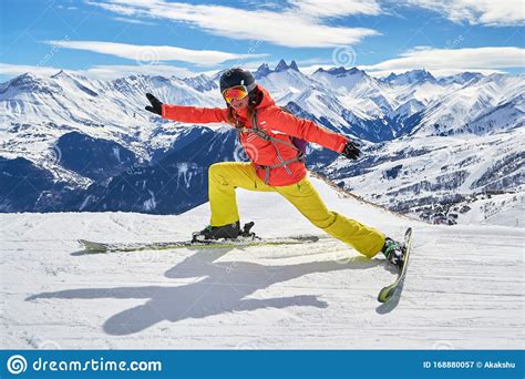 Woman Skier Stretching On Skis With A Funny Pose High Above On A Ski