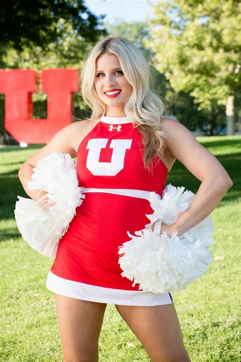 a woman in a red and white cheerleader uniform posing for the camera with her hands on her hips