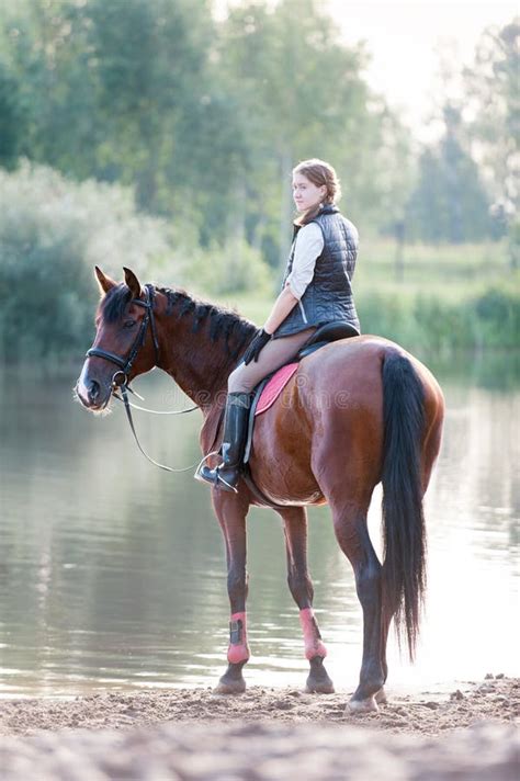 Young Teenage Girl Riding Horseback To River At Early Morning Stock