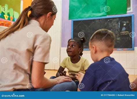 Kindergarten Teacher And Two Children Talk And Play Stock Photo Image
