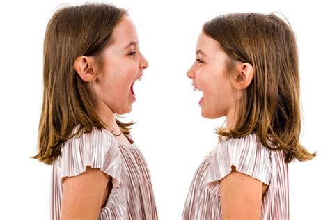 Premium Photo Close Up Of Twins Standing Face To Face With Mouth Open