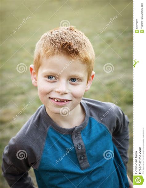 Cute And Silly Little Red Haired Boy Portrait Outdoors