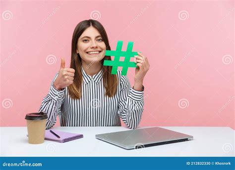 Positive Smiling Woman Blogger Showing Thumbs Up Like Gesture Holding Green Symbol Of Hashtag