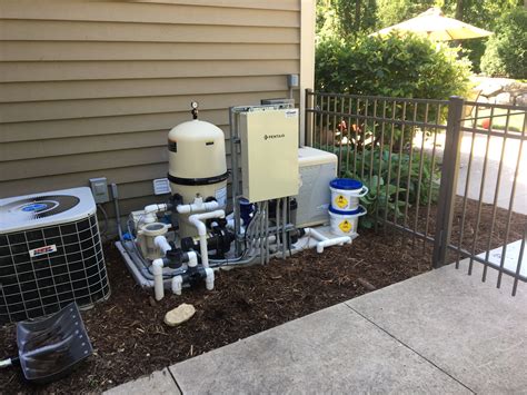 An Air Conditioner And Water Heater Outside On The Side Of A House Next