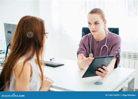Female Doctor In Purple Uniform Giving A Consultation To A Patient And