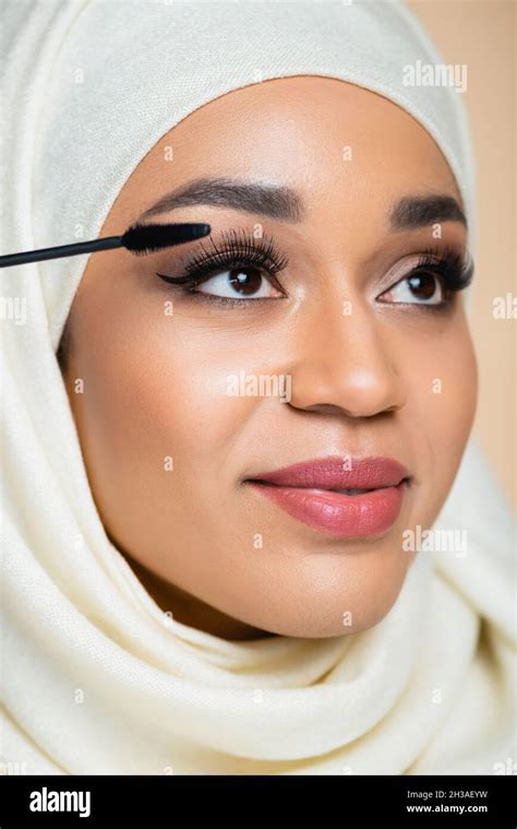 Close Up Of Happy Muslim Woman In Hijab Applying Mascara With Brush