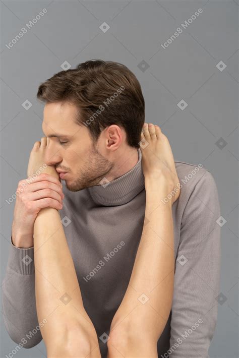 Фото Довольный молодой человек целует женскую ногу